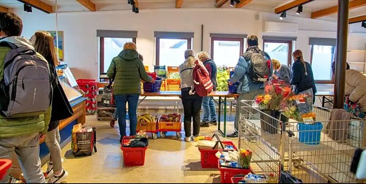 Auf dem Bild sieht man verschiedene Personen im Tettnang Tafelladen, die gerade einkaufen.