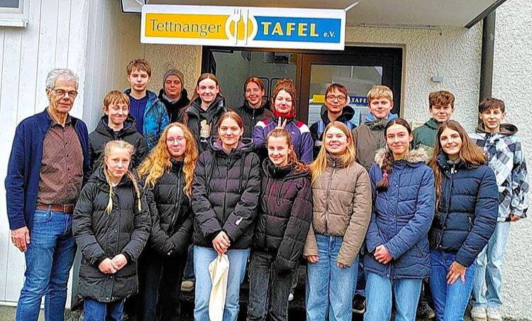 das bild zeigt eine gruppe junger menschen, die konfirmantinnen und konfirmanten, mit dem vorstand peter wunderlich vor dem tettnanger tafelladen.